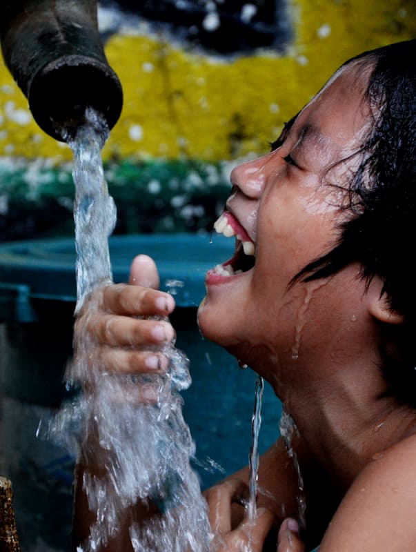 Child drinking clean rainwater highlighting water sanitation and hygiene benefits