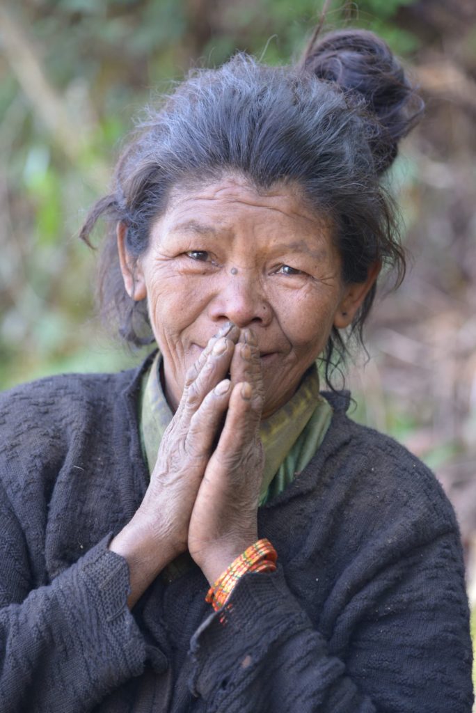 Elder woman in Nepal greeting with hands together in a namaste gesture