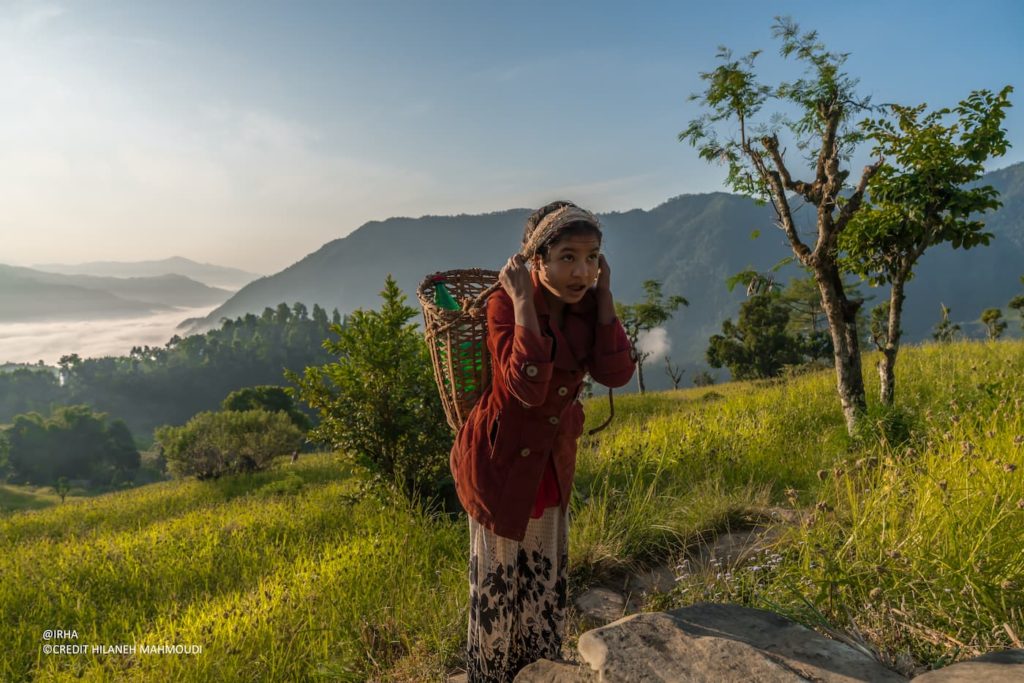 Sushmita carrying a water basket in the Himalayan mountains during her daily journey