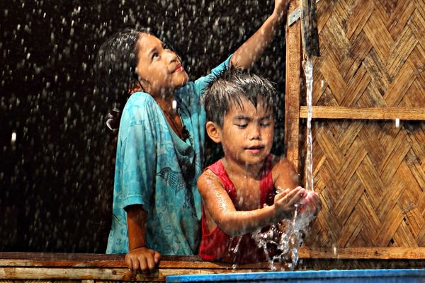 Children collecting rainwater for fire prevention storage